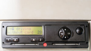 Digital tachograph display reads DRIVING WITHOUT CARD. No inserted card in the device. Insert the drivers card. No personal data.